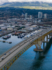 Fototapeta premium Bridge Over Water In Burnaby: Cityscape With Port, Industry, And Mountain Backdrop