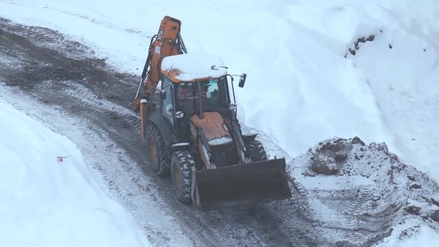Excavator on frozen snow covered construction site at winter