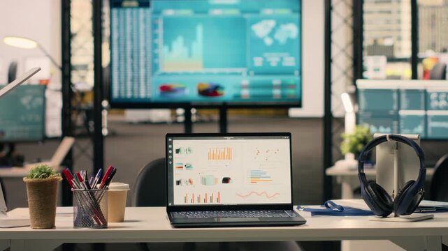 Business KPIs shown on screen in empty executive office setup, work environment decorated with modern furniture and professional supplies. Nobody in stylish office, bright interior.