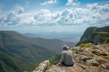 Hiker sitting on cliff overlooking Itaimbezinho Canyon in Brazil © Arthur