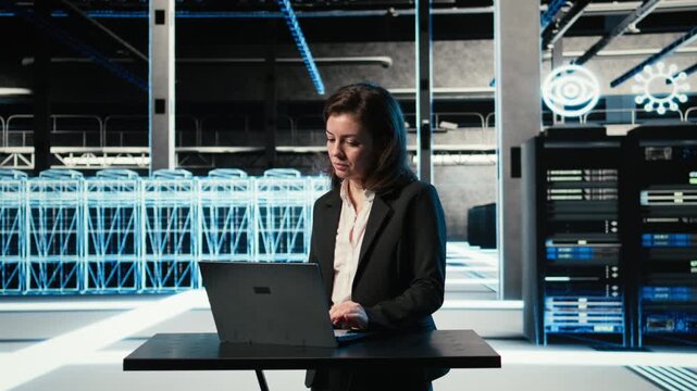 Data center female programmer uses laptop and AR virtualization to troubleshoot electronics issues. Server hub employee using notebook at desk to fix gear system errors, VFX compositing, camera A