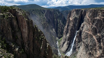 Powerful Waterfall Plunging into Misty Rock Canyon Below