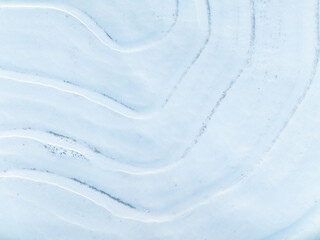 Aerial top down view of patterns of snow drifts in field © Kathryn