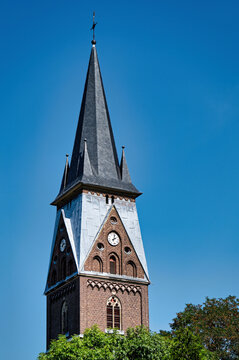 Detail of the neogothic brick steeple and clock of the Catholic parish church St. Martin in Erftstadt-Friesheim, North Rhine-Westphalia, Germany