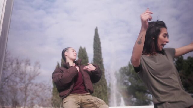 Urban woman freestyling while beatboxer performs in a park