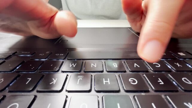 Front view of fingers typing on a laptop keyboard, focusing on black keys, symbolizing technology, digital work, communication, productivity, and the modern lifestyle of online activity