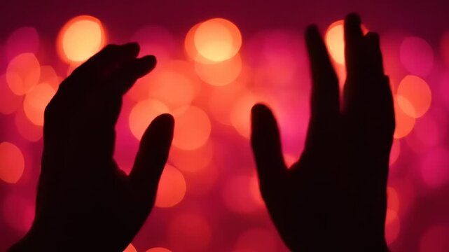 Hands raised in front lights.