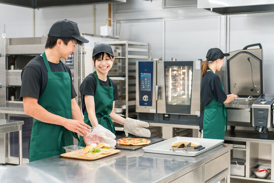 Men and women in uniform working in the kitchen or backyard of a restaurant