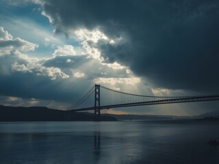 Obraz premium Dramatic Storm Clouds Over Suspension Bridge with Moody Sky and Dark Water Reflection Landscape 