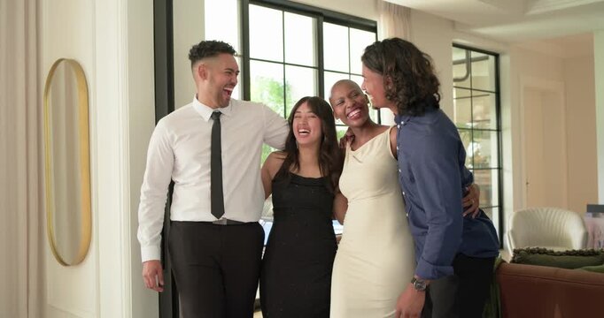 Diverse friends in formal attire standing at home by black door after joke, laughing, clapping