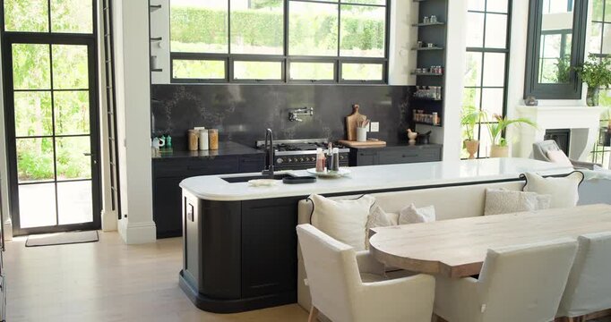 Camera is sliding right and forward, revealing curved island with sink, stove to show cooking area