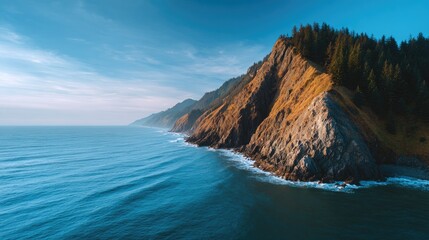 Obraz premium Majestic Coastal Landscape with Rocky Cliffs, Lush Forest, and Expansive Ocean under Clear Blue Sky at Dusk