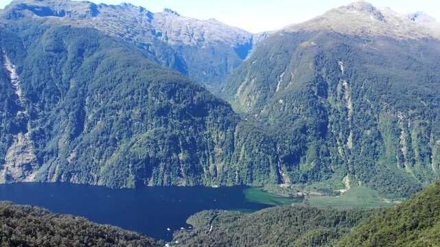 Mountains at Patea, Doubtful Sound fjord in New Zealand. Sunny day, remote travel destination.