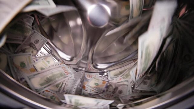 US cash spinning inside a washing machine in slow motion wide angle closeup view. Money laundering concept.
