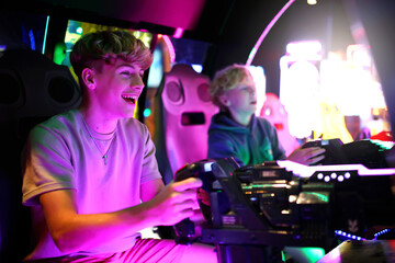 Kids Playing Shooting Video Game in Neon Light Arcade