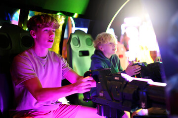 Kids Playing Shooting Video Game in Neon Light Arcade