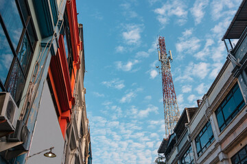 Fototapeta premium Cell phone tower on top of shop house building with clear sky in Surabaya, East Java, Indonesian.