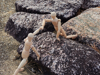 公園の岩場にいる二人の木製のマネキン人形の姿