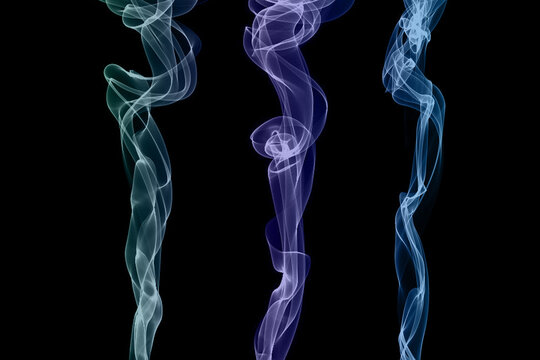 Translucent vibrant coloured smoke whiffs and swirls of aromatic colourful smoke against a black background.