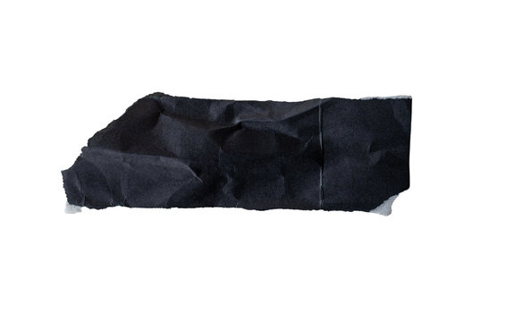 Tira de papel negro rasgado con textura arrugada y bordes irregulares aislada sobre fondo negro
