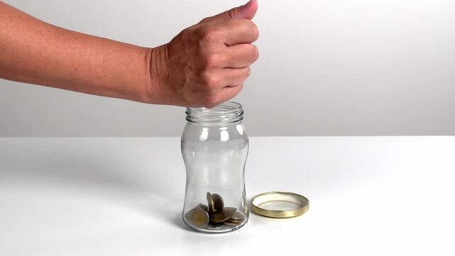 Video with real sound effect of Coins dropping into glass jar.