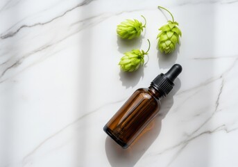 A brown glass bottle with a dropper and hops on a marble surface for herbal or cbd oil products