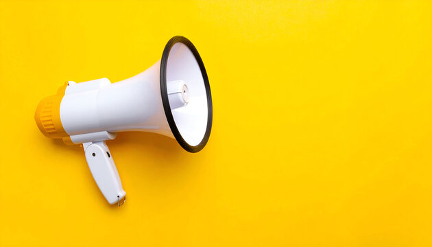 Communication and marketing concept with a megaphone on a vibrant yellow background and copy space.