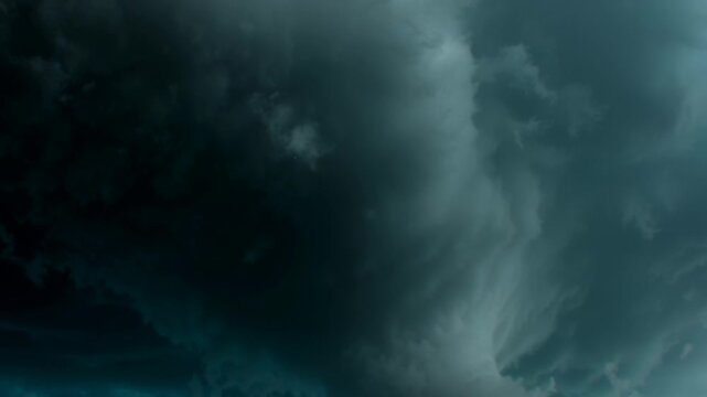 Clouds swirl into vortices forming dramatic tunnel concept. Dark storm clouds swirling in the sky before a thunderstorm with dramatic lighting and intense atmosphere