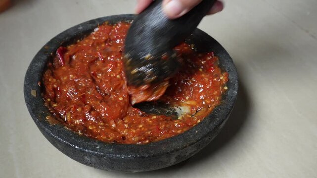 Hand making sambal with traditional tool 