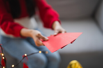 Asian Woman giving red envelope for Lunar New Year celebrations. Hand hold red packet