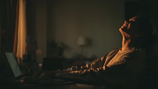 Indian student sitting alone at a desk, quietly exhaling after submitting an online assignment on a laptop, soft evening light, subtle relief, modern Indian study space, candid documentary photography