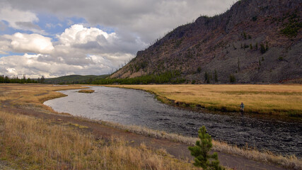 Autumn River Winding Through Golden Meadow and Mountain Slopes