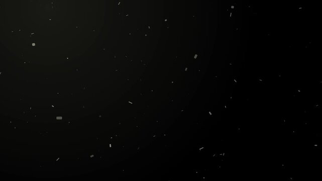 Abstract slow motion dust particles floating and drifting in light on a dark black background