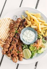 BBQ chicken skewer gyros plate on white table in mykonos  restaurant greece