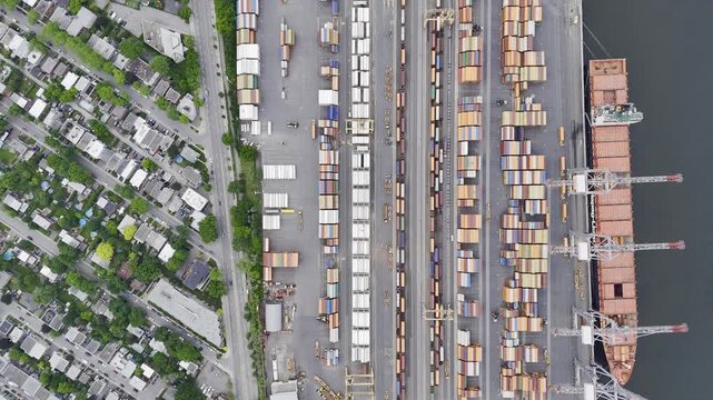 Aerial view of Montreal port with cargo containers, cranes and city skyline at sunset. g.