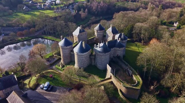 Medieval castle of Lassay-les-Ch&acirc;teaux, showing its eight towers, moat, and surrounding landscape in France. Aerial approach