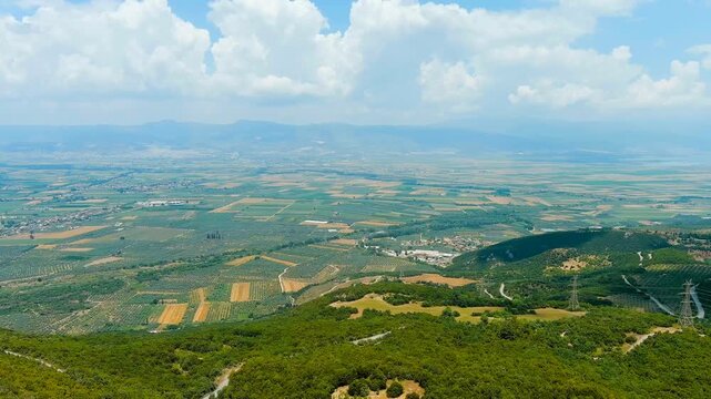 Lamia, Phthiotis, Greece. Panorama of the valley with fields. Olive trees, colorful fields. Summer, Cloudy weather. Drone footage
