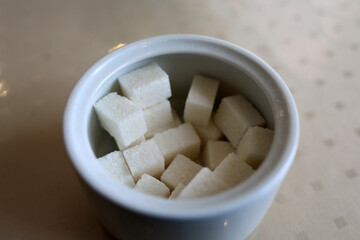 White sugar cubes in ceramic bowl