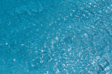 Obraz premium Pool blue water blue abstract texture. Water with ripple waves in Pool. Poolside background. Water pool surface. Pool calm pattern.