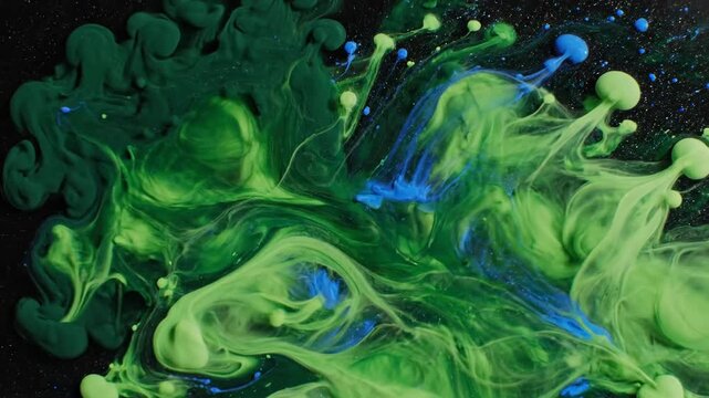 Abstract liquid motion green and blue ink in water creates dynamic shapes