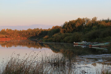 boats on the river bank on a sunny evening in late summer