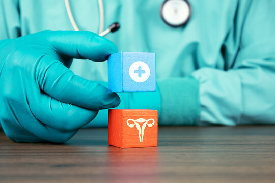 A doctor's hand holding wooden cubes and a uterus icon. Concept of uterine structural abnormalities, myomatosis detection, and clinical approach to fibroids in reproductive health.