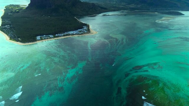 Breathtaking drone footage of the underwater waterfall phenomenon at Le Morne Brabant, where sand and silt runoff create a dramatic optical illusion in turquoise waters.