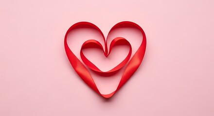A delicate red ribbon heart shape resting on a soft pink background