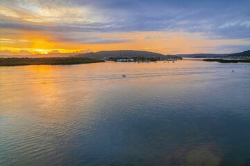 Obraz premium Sunrise waterscape with a mix of low, medium and high clouds