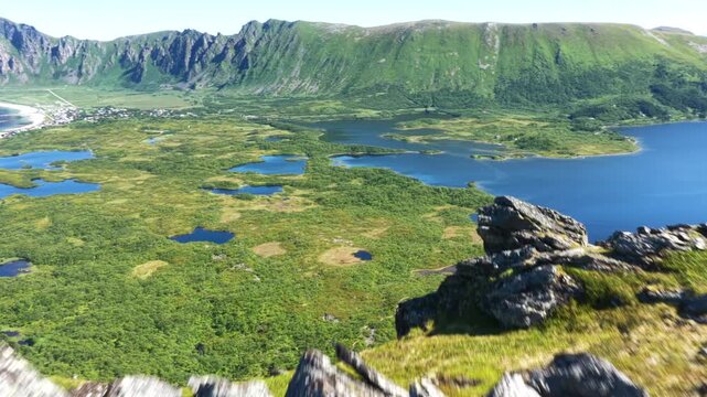 Forward drone flight above Laupen mountain, grassy slope, revealing Bleikmoren, nature reserve on Vesteralen, Vester&aring;len island. Bleik village and some mountains in background. Outdoor travel destinat