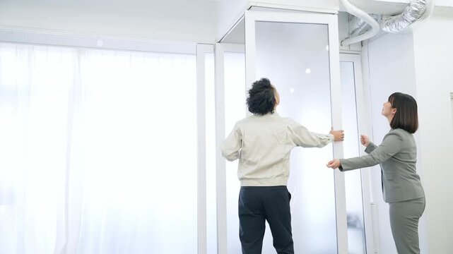 ガラスパーティションを修理する作業員