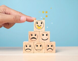 Hand stacking happy face blocks, pyramid of emotions, stars