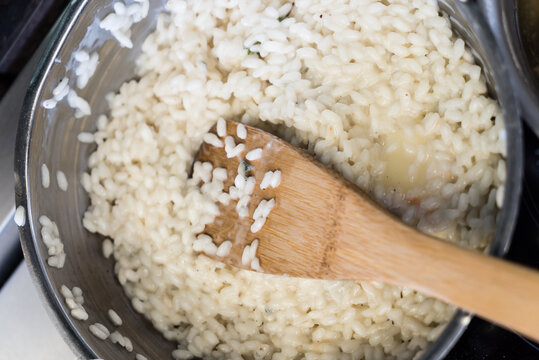 A pot of creamy risotto bubbles softly on the stove as a wooden spoon stirs the tender grains