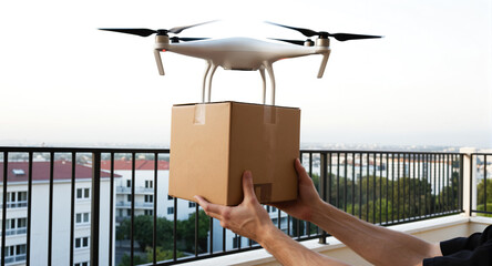 A delivery drone carries a cardboard box parcel